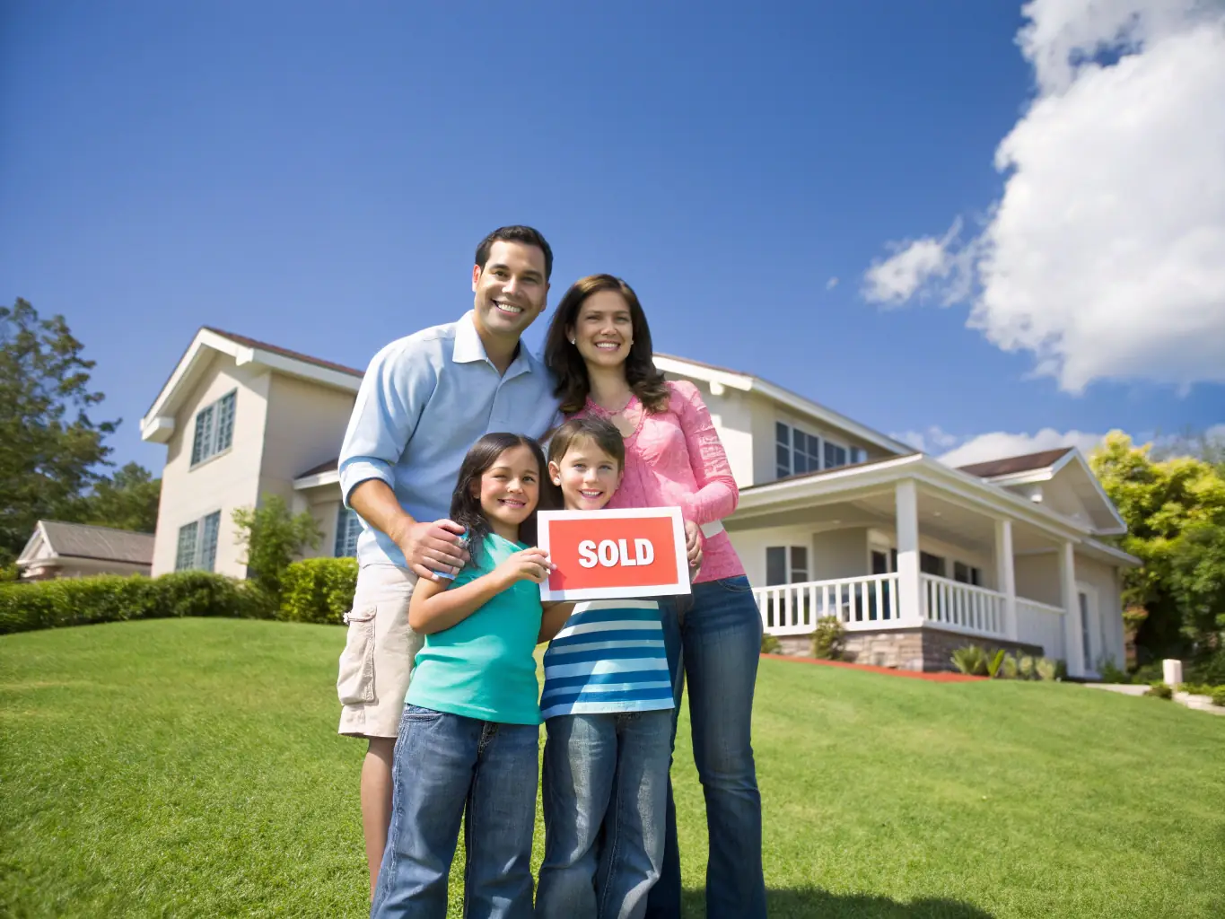 An image showing a family in front of their home with a boat and RV, symbolizing comprehensive personal coverage.